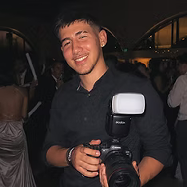 Leonardo Nuñez posando con una camara en las manos y sonriendo